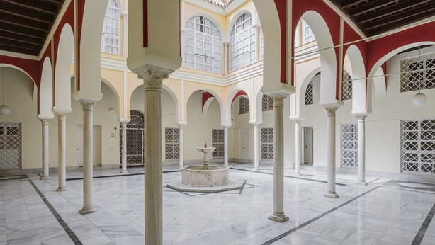 A spacious courtyard with marble flooring, white columns, and arched doorways. - Apartment 'Sevilla Centro Con Piscina' with Shared Pool, Wi-Fi and Air Conditioning (Sevilla)