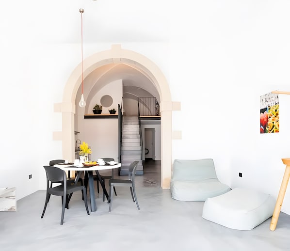 A modern interior with a dining area, a staircase, and a living space.