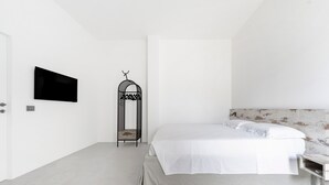 A minimalist bedroom with a bed, a television, and a unique wall-mounted shelf. - Holiday Home 'Tre' with Shared Terrace, Wi-Fi and Air Conditioning (Melendugno)