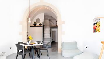 Un interior moderno con comedor, escalera y sala de estar.