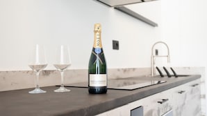 Una botella de champán Moët & Chandon sobre una encimera de cocina, junto a dos copas.
