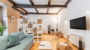 Ein Wohnzimmer mit einer Couch, einem Couchtisch, einem Fernseher und einem Bücherregal.