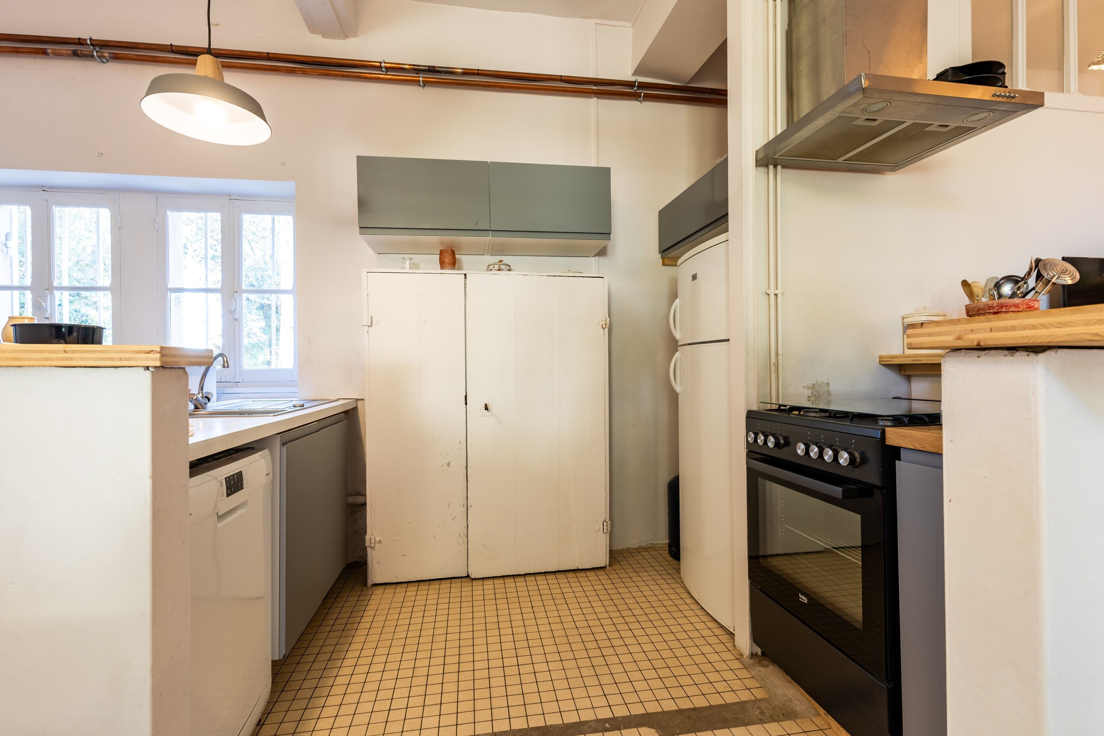 Une cuisine compacte équipée d’une cuisinière, d’un four et d’un réfrigérateur à deux portes.