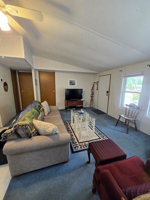 Cozy living space with a sofa, coffee table, and armchair, perfect for relaxing and watching TV.