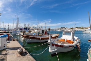 A marina with boats docked, a pier, and a clear sky.