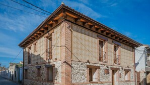 A historic building with a stone facade, multiple windows, and a tiled roof.