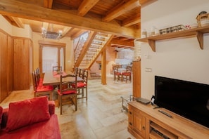 Un interno in legno con zona pranzo, una scala e un televisore.