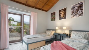 A bedroom with a bed, two bedside tables, a window with curtains, and a view of the outdoors. - 'Casa Del Cielo' with Sea View, Private Pool and Wi-Fi (Adeje)