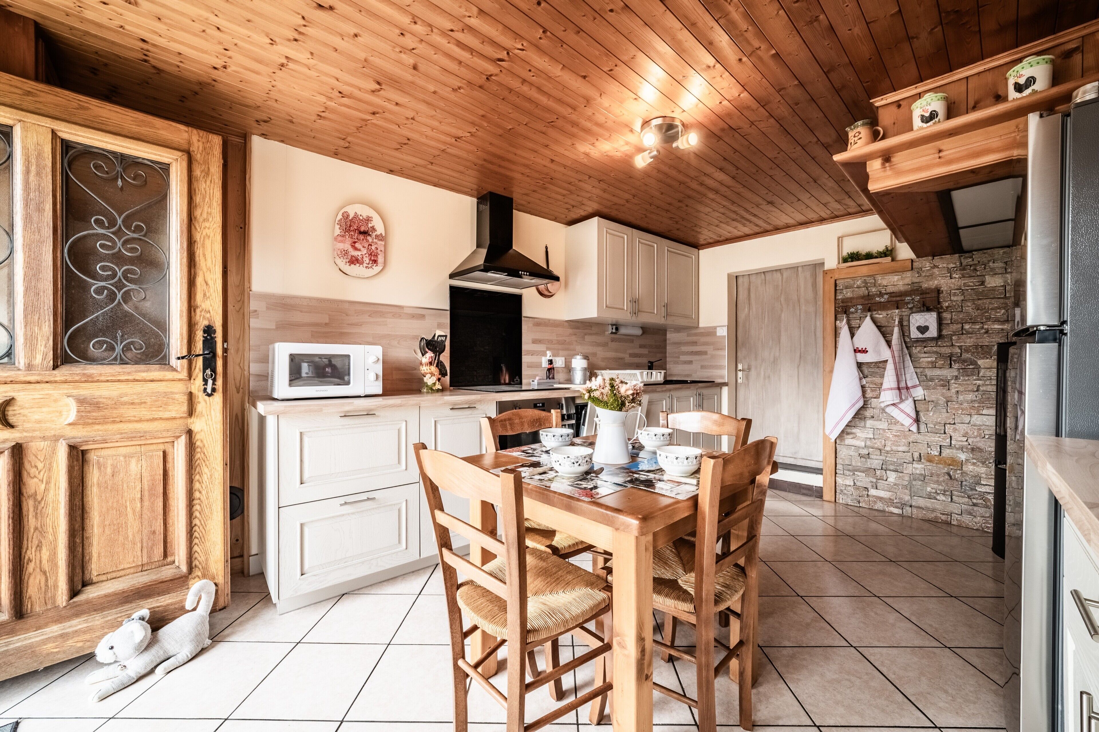 A kitchen with wooden cabinets, a dining table, and a white refrigerator.