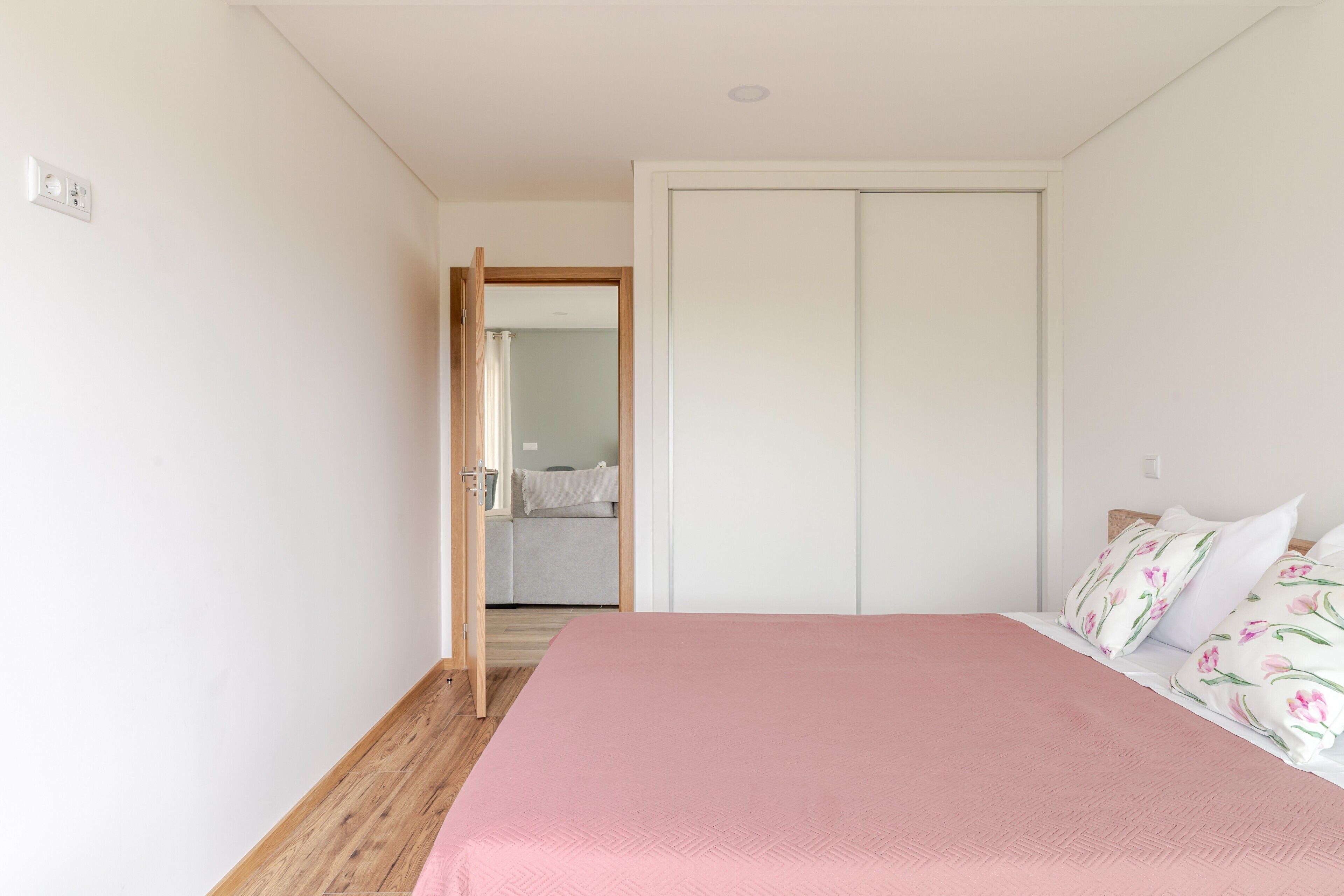 Een slaapkamer met een bed, een kledingkast en een badkamer die door een open deur zichtbaar is.