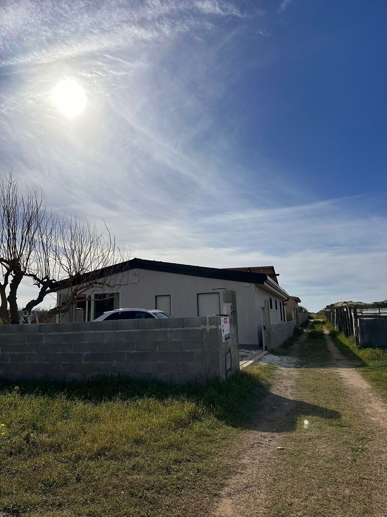 A building with a garage, a paved driveway, and a grassy area.