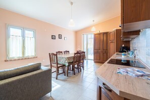 Eine Küche mit Holzausstattung, einem Esstisch mit Stühlen und einer Couch.