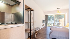 Una habitación moderna con cocina, cama, zona de estar y vistas al exterior.