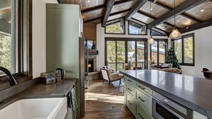 Een moderne keuken met een groot kookeiland, houten vloeren en een open haard.