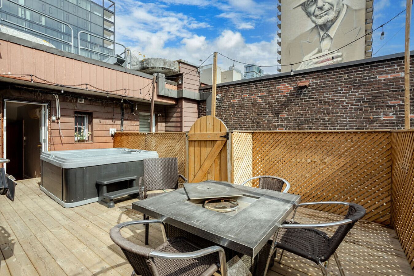 An outdoor patio with a hot tub, table, and chairs.