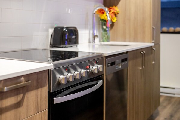 A kitchen with a built-in oven, a dishwasher, and a toaster. - Cute 1BDR Apt; Ste-Catherine - MTL Live Spot (Montréal)