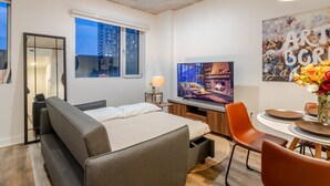 Une chambre d’hôtel moderne équipée d’un lit, d’une télévision, d’un bureau et d’un coin repas.