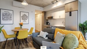 Un appartement moderne comprenant un coin repas, un canapé et une cuisine.