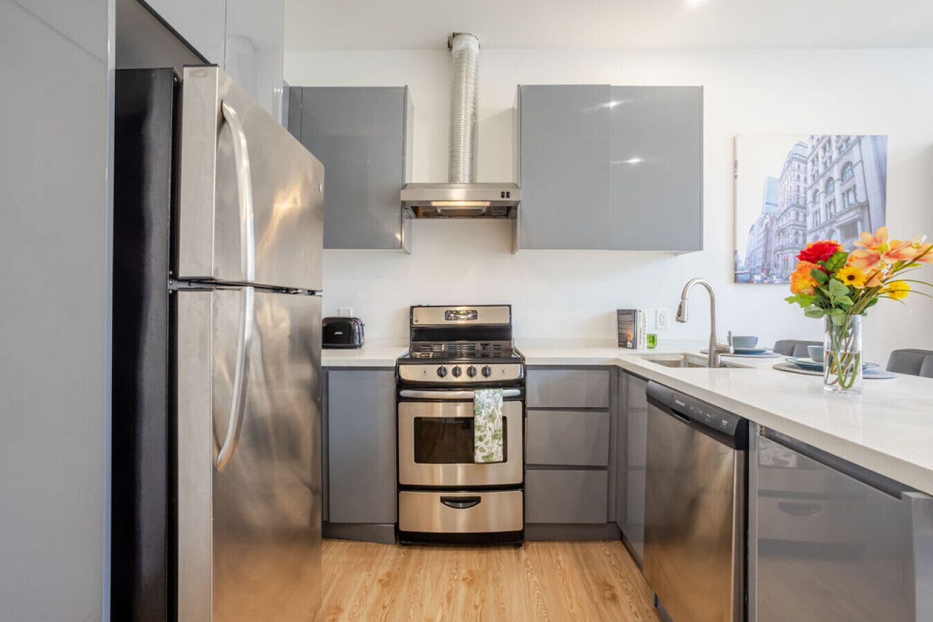 A modern kitchen with stainless steel appliances, a built-in oven, and a dishwasher.