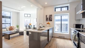 A modern kitchen with a central island, built-in appliances, and large windows.