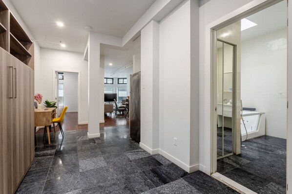 A modern interior with a kitchen, dining area, and a bathroom. - Vibrant MTL Living – 1BDR in a Top Location (Montréal)