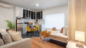 A compact living space with a kitchenette, dining area, and seating area. - Spacious Bishop Apartment –Prime Downtown Stay (Montréal)