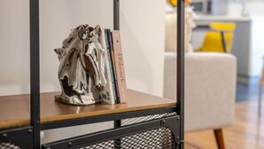 A metal shelf unit with a decorative sculpture and books. - Spacious Bishop Apartment –Prime Downtown Stay (Montréal)