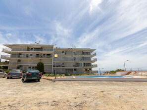 A multi-story building with balconies, a swimming pool, and a parking area. - Apartment Ulises by Interhome (Salou)