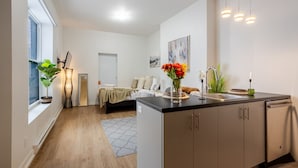 A modern apartment with a kitchen, a dining area, and a bedroom.