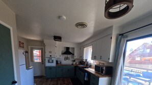 A compact kitchen with a central island, built-in appliances, and a view of the outdoor deck.