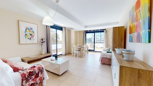 Una sala de estar moderna con sofá, mesa de centro y comedor.