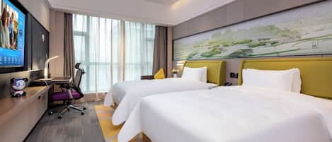 A hotel room with two beds, a desk with a computer, a TV, and a large window with curtains.