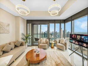 Un salon moderne doté d’un grand téléviseur, de sièges confortables et offrant une vue sur la ville.