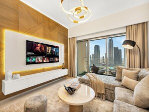 A modern living room with a flat-screen TV, a sofa, a coffee table, and a view of the city skyline.