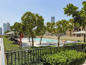 A rooftop pool area with lounge chairs and a swimming pool.