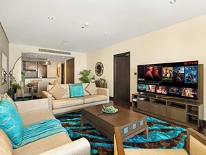 A modern living room with a sofa, coffee table, and a flat-screen TV displaying Netflix content.