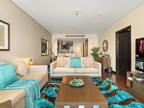 A modern living room with a sofa, coffee table, and television. - Anantara Sea & Burj Al Arab View / Private Beach (Dubai)