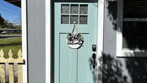 A house with a light blue door, a welcome sign, and a doormat. - The Level Up Studio (Jacksonville)