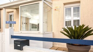 Une maison de vacances avec une porte en verre, une boîte aux lettres et un panneau indiquant qu’il s’agit d’une maison de vacances.