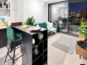 Una cocina moderna con comedor, sofá y vistas de la ciudad por la noche.