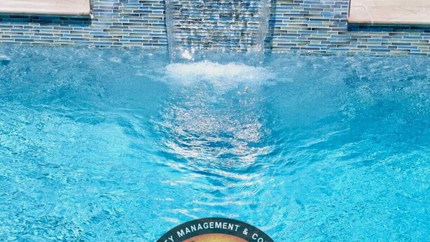 A swimming pool with a waterfall feature and a logo for 'Sunsational' at the bottom. - Villa Flores- New Modern Luxury Villa within walking distance from ANR Airport. (Bon Accord)