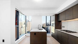 Une cuisine moderne dotée d’un îlot central, de grandes fenêtres et offrant une vue sur la ville.