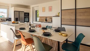Een moderne keuken met een centraal eiland, een eettafel en stoelen.