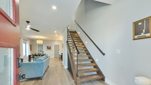 A modern interior with a staircase, a blue sofa, and a Bauhaus poster. - Veranda with skyline views (Atlanta)