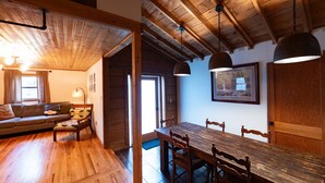 Un interior de madera con un sofá, una mesa de comedor y lámparas colgantes.