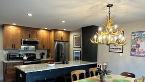 Una cocina moderna con armarios de madera, electrodomésticos de acero inoxidable y una isla central con asientos.