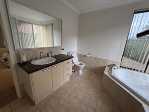 A bathroom with a sink, mirror, toilet, and bathtub. - Coastal retreat in Secret Harbour (Secret harbour)