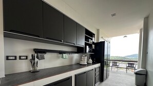 A modern kitchen with dark cabinets, a countertop, and a view of the outdoors.