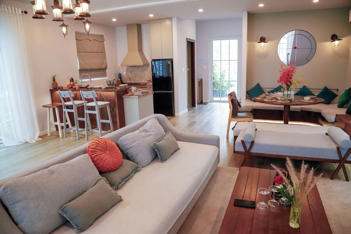 Ein modernes Wohnzimmer mit Sofa, Esstisch und Küchenzeile.
