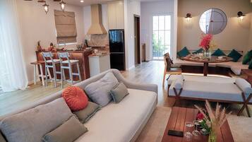 Una sala moderna con sofá, mesa de comedor y zona de cocina.